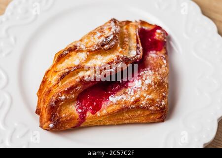 Pâte feuilletée avec confiture rouge sur une assiette blanche Banque D'Images
