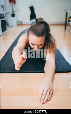 Europe, Allemagne, Rosenheim, Jeune Femme fait de l'entraînement sportif à domicile, Livingroom Banque D'Images