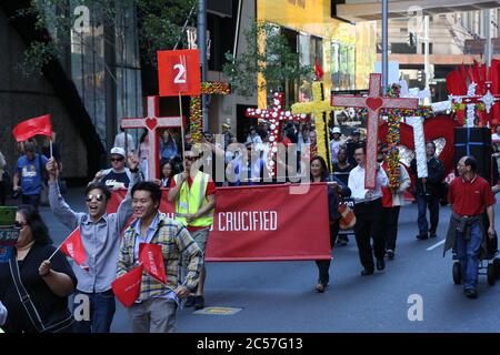 Les chrétiens participant à la parade de Pâques de Sydney portent des croix tandis que la parade se rend le long de Market Street, au cœur du busi central de Sydney Banque D'Images