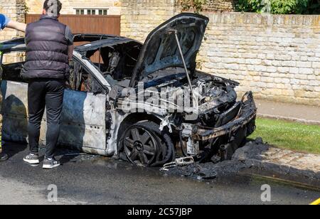 Une voiture complètement brûlée sur le côté de la route à High Street, Chipping Campden, une petite ville marchande dans les Cotswolds à Gloucestershire Banque D'Images