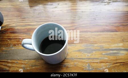 Vue de dessus d'une tasse de café blanc vide sur un ancienne table en bois Banque D'Images