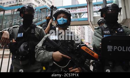 Hong Kong, CHINE. 1er juillet 2020. La police anti-émeutes est mobilisée pour se tenir à l'écoute de tous les points stratégiques d'une ville, pour empêcher les citoyens de se rassembler et lancer une marche de protestation.loin derrière sur le survol, voir un slogan politique pro-Beijing sur la bannière qui se lit : 'Transfert de l'émission de la loi nationale de sécurité'.1 juillet-1, 2020 Hong Kong.ZUMA/Liau Chung-ren crédit: Liau Chung-ren/ZUMA Wire/Alay Live News Banque D'Images