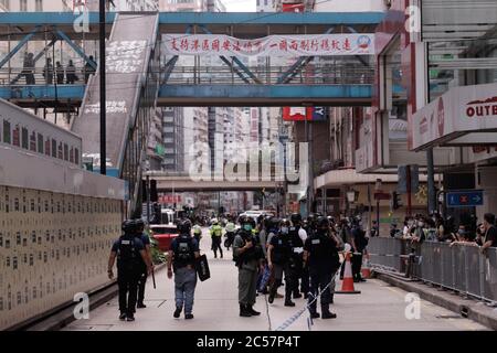Hong Kong, CHINE. 1er juillet 2020. Un grand nombre de policiers de Riot sont mobilisés pour contrôler les foules lors du RASSEMBLEMENT annuel du 1er JUILLET afin d'empêcher les citoyens de se réunir et d'initier une marche de protestation. Loin derrière sur le survol est une exposition de la bannière politique pro-Beijing qui se lit : "l'émission de la loi de SÉCURITÉ NATIONALE de HK, un pays deux système sera stabilisé et durera longtemps".1 juillet-2020 Hong Kong.ZUMA/Liau Chung-ren crédit: Liau Chung-ren/ZUMA Wire/Alay Live News Banque D'Images