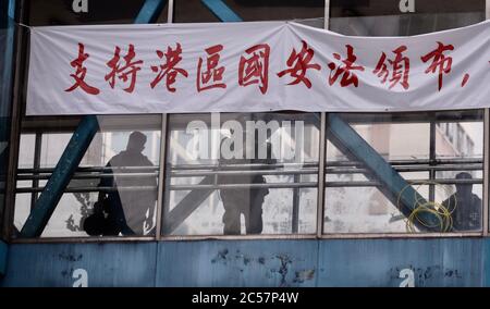 Hong Kong, CHINE. 1er juillet 2020. Le slogan politique pro-Beijing est affiché sur la bannière attachée à un survol qui se lit comme suit : 'assurer l'émission de LA LOI de SÉCURITÉ NATIONALE HK'.1 juillet-2020 Hong Kong.ZUMA/Liau Chung-ren crédit: Liau Chung-ren/ZUMA Wire/Alay Live News Banque D'Images