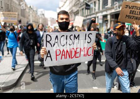 Un homme tient un signe de protestation lors d'une marche de Black Lives Matter, Londres, 27 juin 2020 Banque D'Images