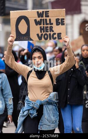 Une femme tient un signe de protestation au-dessus de sa tête lors d'une manifestation Black Lives Matter, Londres, 27 juin 2020 Banque D'Images