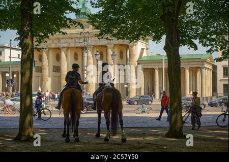 Berlin, Allemagne - 8 mai 2020 : une femme et un homme de la police montée de Berlin dans le Tiergarten près de la porte de Brandebourg. Banque D'Images