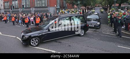 Le cortège funéraire de Noah Donohoe, 14 ans, quitte son école, le collège St Malachy à Belfast, où il s'est mis en pause pendant un court moment flanqué de ses camarades de classe, après son service funéraire privé à l'église Saint Patrick. Banque D'Images