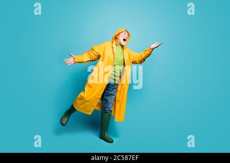 Vue de sa taille de corps pleine longueur de son il gentil gai positif gris-cheveux homme portant le dessus jaune attrapant la goutte de pluie ayant amusant isolé sur lumineux Banque D'Images