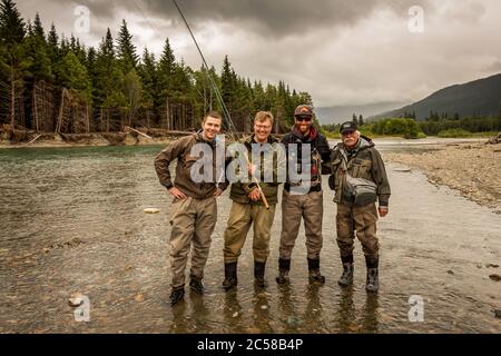 Un sport de groupe heureux vole des amis pêcheurs sur une belle scène de rivière en Colombie-Britannique, Canada Banque D'Images