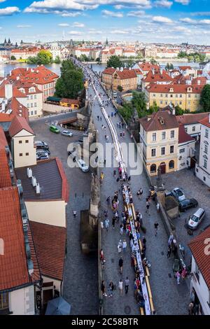 Des milliers de personnes se sont assises à une table de 500 mètres de long sur le pont Charles de Prague, où elles partageait nourriture et boissons de leur domicile Banque D'Images