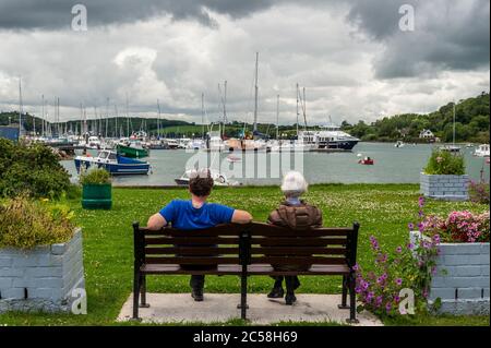 Crosshaven, West Cork, Irlande. 1er juillet 2020. Par une journée très chaude mais très cousue, un couple s'assoit sur un banc donnant sur la marina de Crosshaven. Crédit : AG News/Alay Live News Banque D'Images