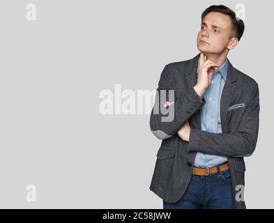 Un homme élégant dans un vêtement élégant est à la recherche de côté et de penser. Studio isolé Banque D'Images