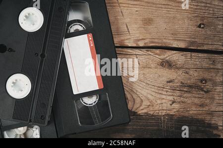 Pile de cassettes vidéo VHS sur fond de bois. Vue de dessus. Image de style rétro Banque D'Images