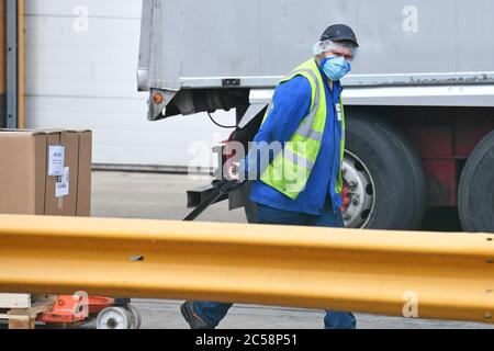 Un travailleur portant un masque facial à l'usine Walkers Crisp de Leicester après que l'entreprise a confirmé qu'il y a eu 28 cas positifs de Covid-19 sur le site. Banque D'Images