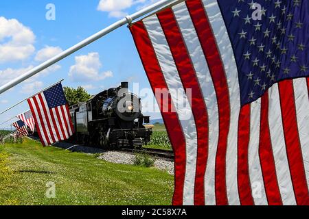 29 juin 2020 : la locomotive à vapeur Strasburg Railroad, Norfolk & Western, 475 passe un groupe de drapeaux américains lors de son retour à la gare le lundi 29 juin 2020, à Ronks, Pennsylvanie. Le chemin de fer de Strasburg a rouvert ses portes pour le service passagers le vendredi 26 juin, après avoir été fermé en raison de la pandémie COVID-19. Des mesures de sécurité supplémentaires liées à la santé ont été mises en place pour la réouverture. Riche Barnes/CSM Banque D'Images