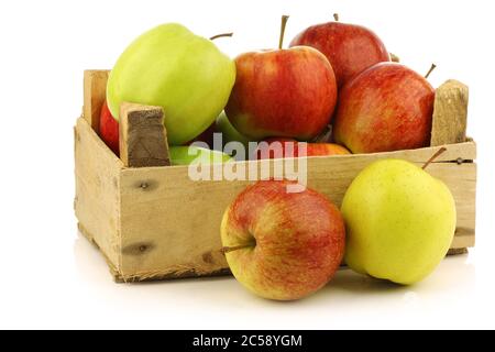 assortiment de pommes fraîches dans une caisse en bois sur fond blanc Banque D'Images