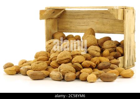 assortiment de noix dans une boîte en bois sur fond blanc Banque D'Images