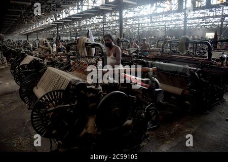 DHAKA, BANGLADESH - 01JULY 2020: Travailleurs qui travaillent à la fabrication de sacs de jute dans l'usine de traitement de jute de Narayanganj, près de Dhaka. L'industrie du jute au Bangladesh est une industrie qui revêt une importance historique et culturelle et qui était autrefois la plus grande industrie de la région. Banque D'Images