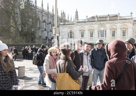 Groupe de jeunes touristes chinois vus dans un groupe à l'extérieur du célèbre Kings College. Banque D'Images