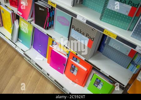 Sélection colorée de tailles et de styles variés de carnets et autres produits fixes vus sur les tablettes inférieures d'une librairie bien connue. Banque D'Images