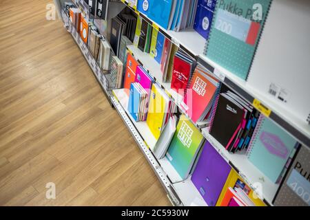Sélection colorée de tailles et de styles variés de carnets et autres produits fixes vus sur les tablettes inférieures d'une librairie bien connue. Banque D'Images