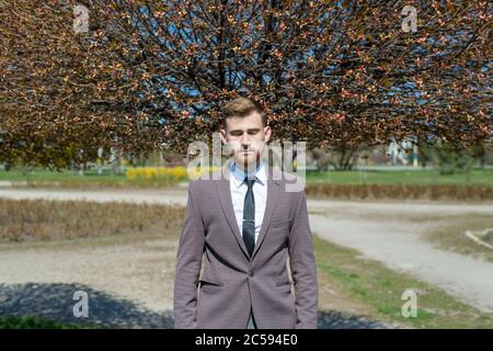 Portrait d'un jeune homme barbu avec les yeux fermés, de la tête dont pousse un arbre. En plein air. Dans la tonification artistique créative. Concept d'entreprise la naissance Banque D'Images