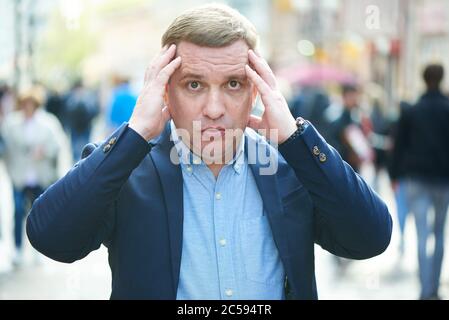 un homme perplexe est debout dans la rue Banque D'Images