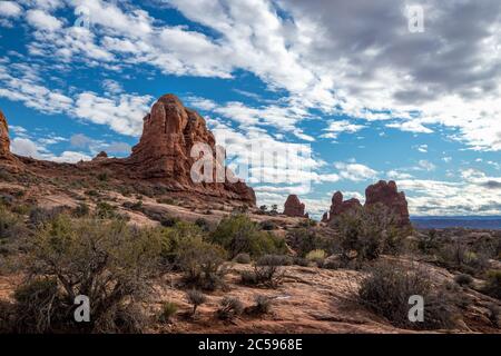 Magnifique paysage de nuages sur Turret Arch et les formations rocheuses de grès environnantes par une journée ensoleillée, Parc national d'Arches, Moab, Utah Banque D'Images