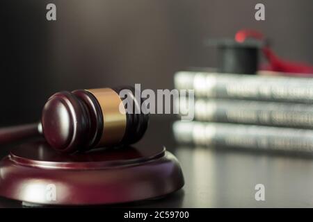 Le gavel du juge avec des livres et un chapeau de graduation sur le fond. Concept de droit, justice, éducation, diplôme et étude internationale. Banque D'Images