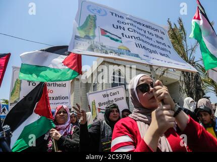 Les Palestiniens affichent des plaques et lèvent leur drapeau national lors de la protestation contre le projet d'Israël d'annexer des parties de la Cisjordanie occupée, à Gaza.les attentes d'une annonce israélienne majeure sur les annexions controversées en Cisjordanie occupée se sont estompées, Alors que la critique mondiale du projet s'est montée et que les manifestants palestiniens ont commencé à se rassembler à Gaza. Banque D'Images