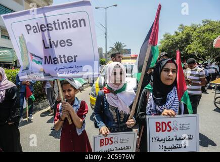 Les Palestiniens affichent des plaques et lèvent leur drapeau national lors de la protestation contre le projet d'Israël d'annexer des parties de la Cisjordanie occupée, à Gaza.les attentes d'une annonce israélienne majeure sur les annexions controversées en Cisjordanie occupée se sont estompées, Alors que la critique mondiale du projet s'est montée et que les manifestants palestiniens ont commencé à se rassembler à Gaza. Banque D'Images