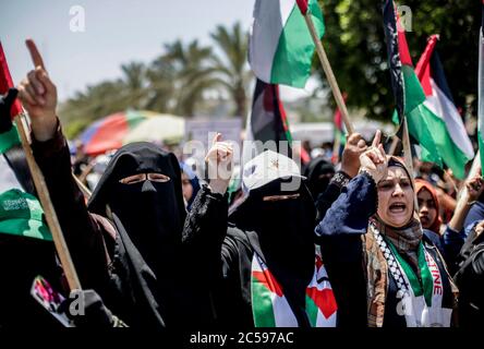 Les femmes palestiniennes chantent et lèvent des pancartes et des drapeaux nationaux lors d'une manifestation contre les plans d'annexion d'Israël en Cisjordanie à Gaza.les attentes d'une annonce israélienne majeure sur les annexions controversées en Cisjordanie occupée se sont atténuées, alors que les critiques mondiales du projet se sont montées et que les manifestants palestiniens ont commencé à se rassembler à Gaza. Banque D'Images