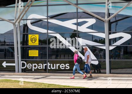 Premier vol passager depuis l'aéroport Southend de Londres, Essex, Royaume-Uni, après le verrouillage du coronavirus COVID-19. Personnes arrivant au terminal des départs. Masques Banque D'Images