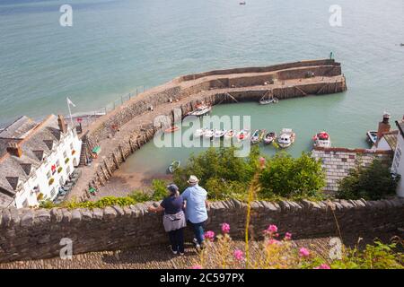 Couple d'âge moyen appréciant la vue sur le port de Clovelly, North Devon, Angleterre, été Banque D'Images