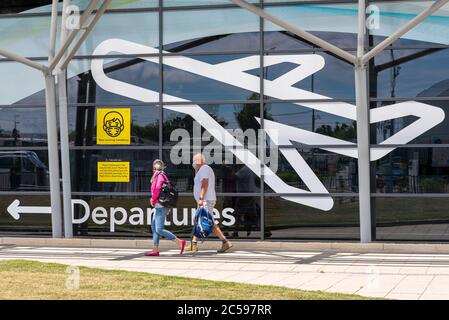 Premier vol passager depuis l'aéroport Southend de Londres, Essex, Royaume-Uni, après le verrouillage du coronavirus COVID-19. Personnes arrivant au terminal des départs. Masques Banque D'Images