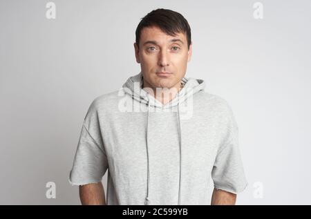 Portrait d'un homme en pull à capuche isolé sur fond gris Banque D'Images