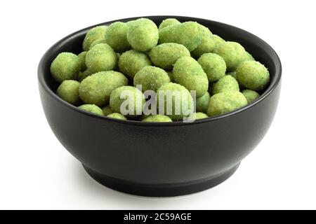 Arachides enrobées de Wasabi dans un bol en céramique noire isolé sur blanc. Angle élevé. Banque D'Images