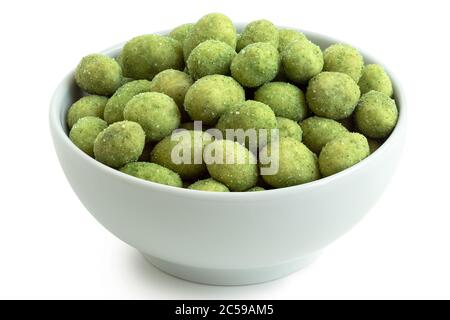 Arachides enrobées de Wasabi dans un bol en céramique blanc isolé sur blanc. Angle élevé. Banque D'Images