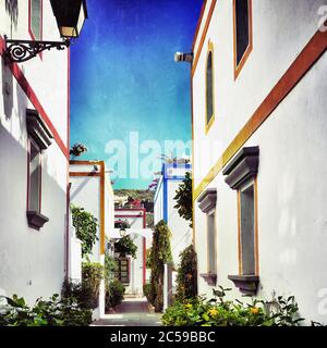 Rue avec maisons blanches colonia montré à Puerto de Mogan, Espagne. Lieu de vacances préféré pour les touristes et les habitants de l'île. Filtré Banque D'Images