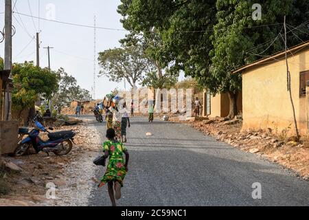 Afrique, Afrique de l'Ouest, Bénin, Natitinqou. Une jeune fille africaine qui court sur la route. Banque D'Images