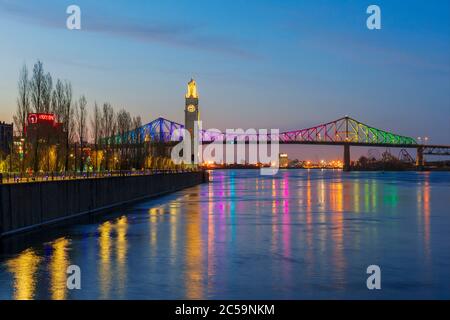 Canada, province de Québec, Montréal, le pont Jacques-Cartier illuminé dans les couleurs de l'arc-en-ciel, période de confinement de la COVID-19, le fleuve Saint-Laurent, la Tour de l'horloge Banque D'Images