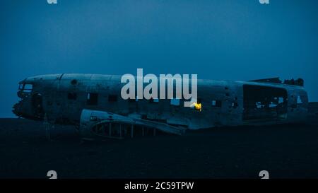 Randonneur à la vue d'un avion abandonné en Islande la nuit. Banque D'Images
