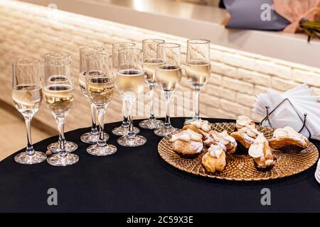 Champagne en verres et une assiette de gâteaux sur le tableau Banque D'Images