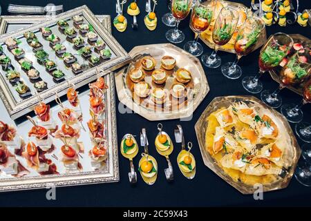 Différents desserts dans des assiettes sur une table noire Banque D'Images