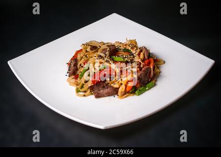 Assiette de légumes et de viande sur une assiette blanche sur fond noir Banque D'Images