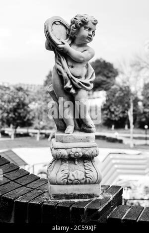Statue d'un garçon sur un mur de pierre noir et blanc Banque D'Images