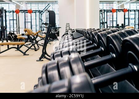 Une rangée d'haltères noires dans la salle de sport Banque D'Images