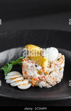 Salade traditionnelle olivie avec mayonnaise à base de légumes cuits hachés, œufs, viande Banque D'Images