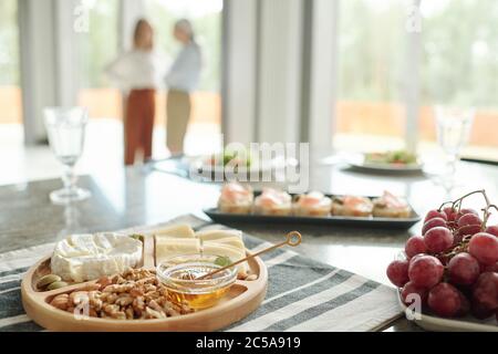 Gros plan de divers en-cas tels que hors-d'œuvre, fromages et raisins sur la table à manger Banque D'Images